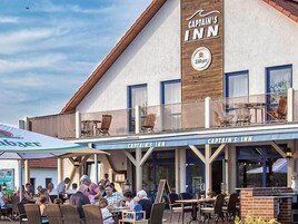 Captain's Inn with outdoor seating and a beer sign.