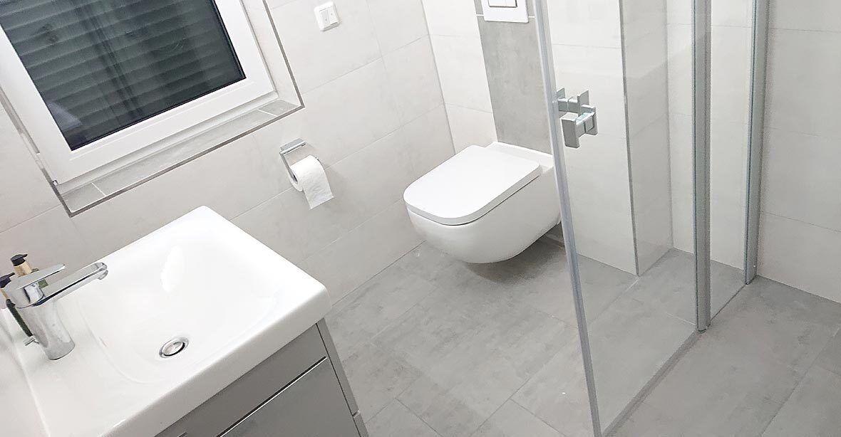 Ein modernes Badezimmer mit Waschbecken, Toilette und Duschkabine aus Glas.