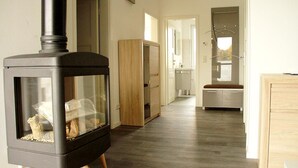 Un interno moderno con stufa a legna, un mobile in legno e un angolo cottura.