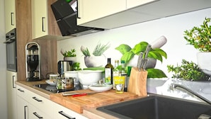 Una cucina moderna con un piano di lavoro in legno, un lavello e diversi elettrodomestici.