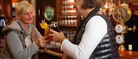 Une scène de bar où une personne verse une boisson dans un verre.