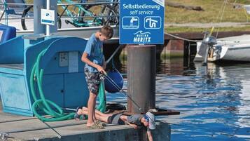 Ein Yachthafen mit Selbstbedienungsstation, einer Anlegestelle und Booten im Hintergrund.