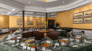 A buffet setup with various food items and a marble counter.