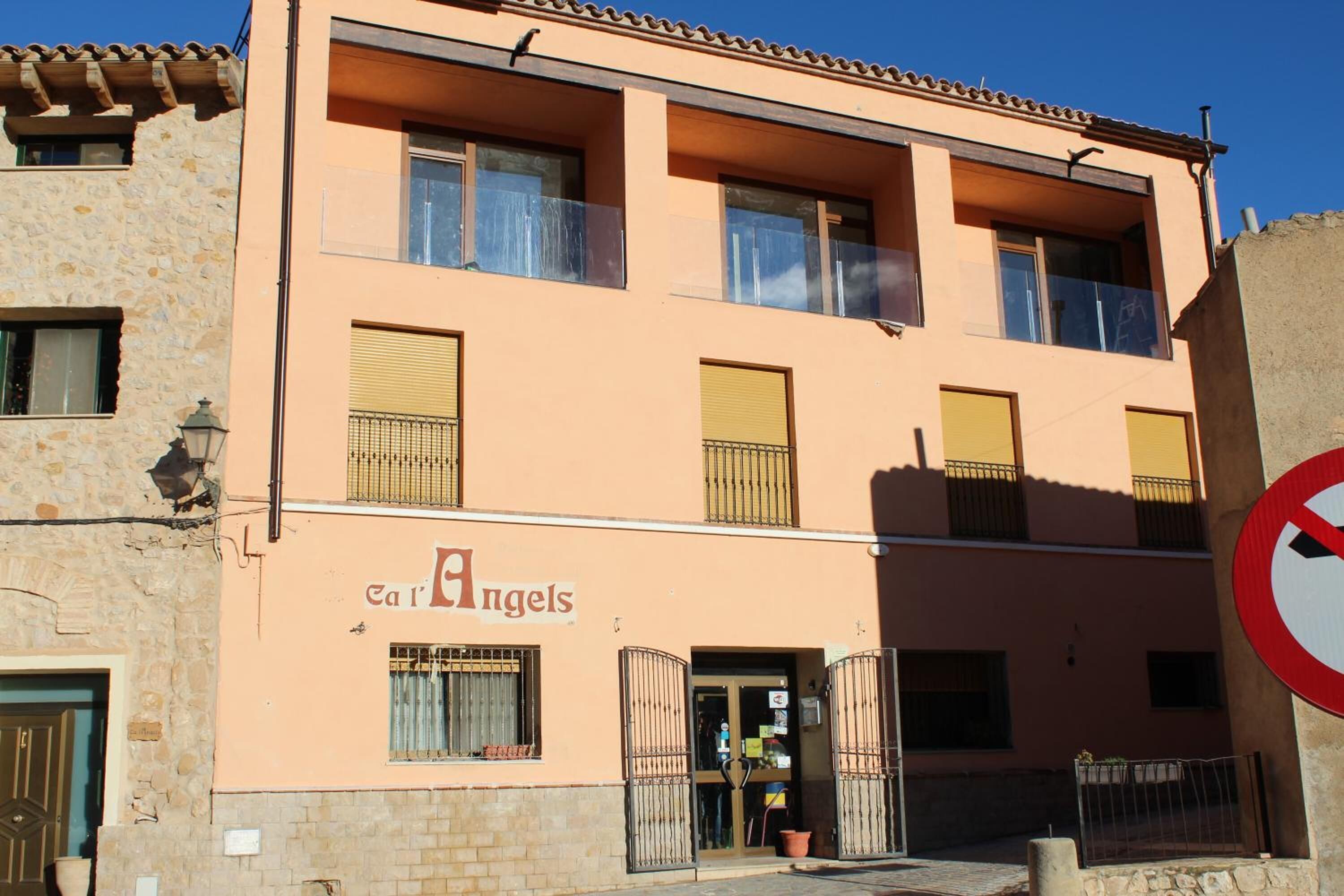 Um edifício de dois andares com uma placa na entrada que diz 'Car Angels'.