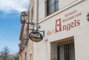 Un edificio con un cartel de Coca-Cola y un cartel que indica 'Rest. Ca l'Angels'.