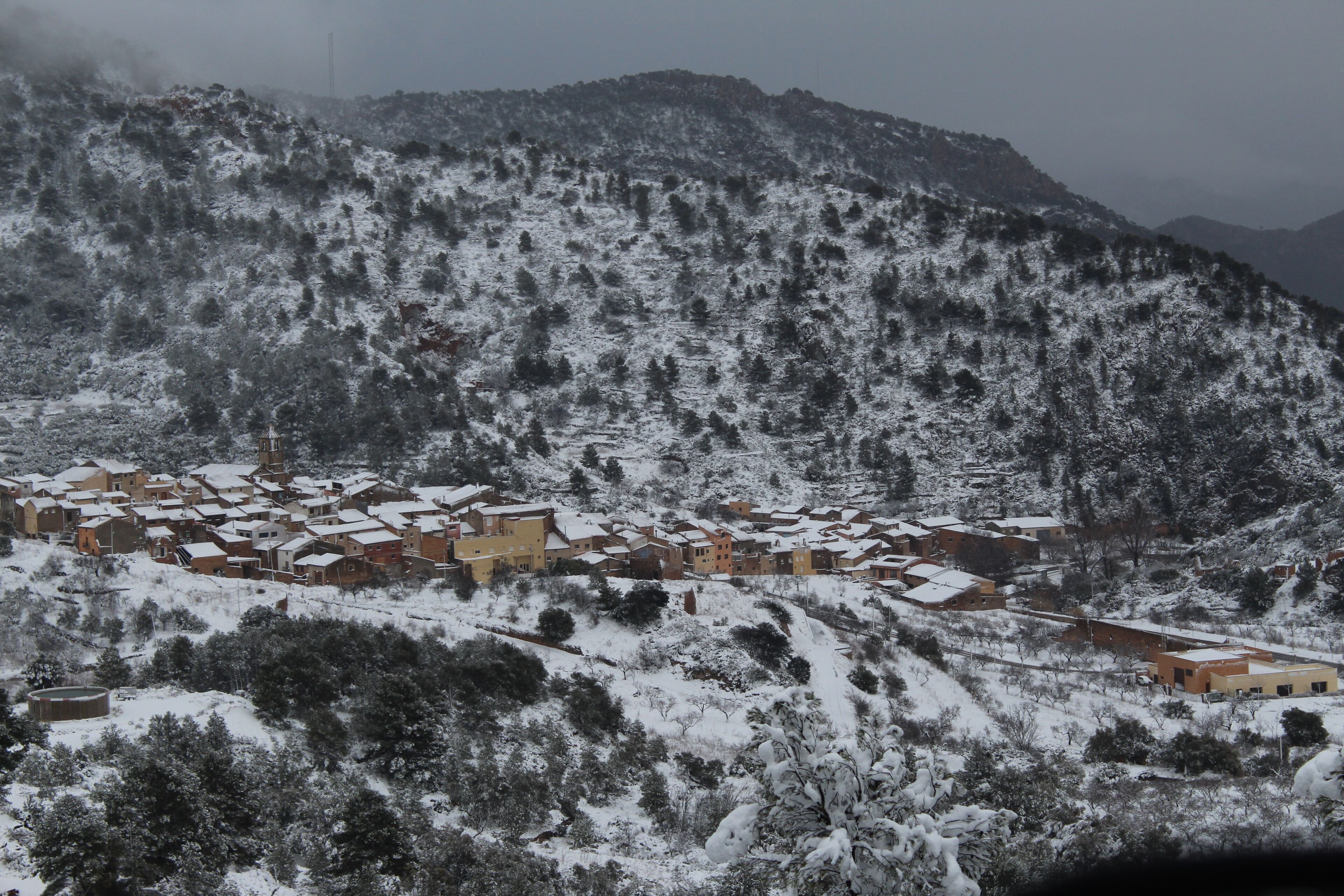 A snow-covered village with traditional buildings and a prominent church.