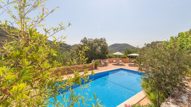 A swimming pool with a view of mountains, surrounded by greenery and a lounge area with chairs and umbrellas. - Aire Can Pieres, Finca 5StarsHome Mallorca (Esporlas)