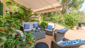 An outdoor patio area with wicker furniture, a covered seating area, and lush greenery. - Aire Can Pieres, Finca 5StarsHome Mallorca (Esporlas)