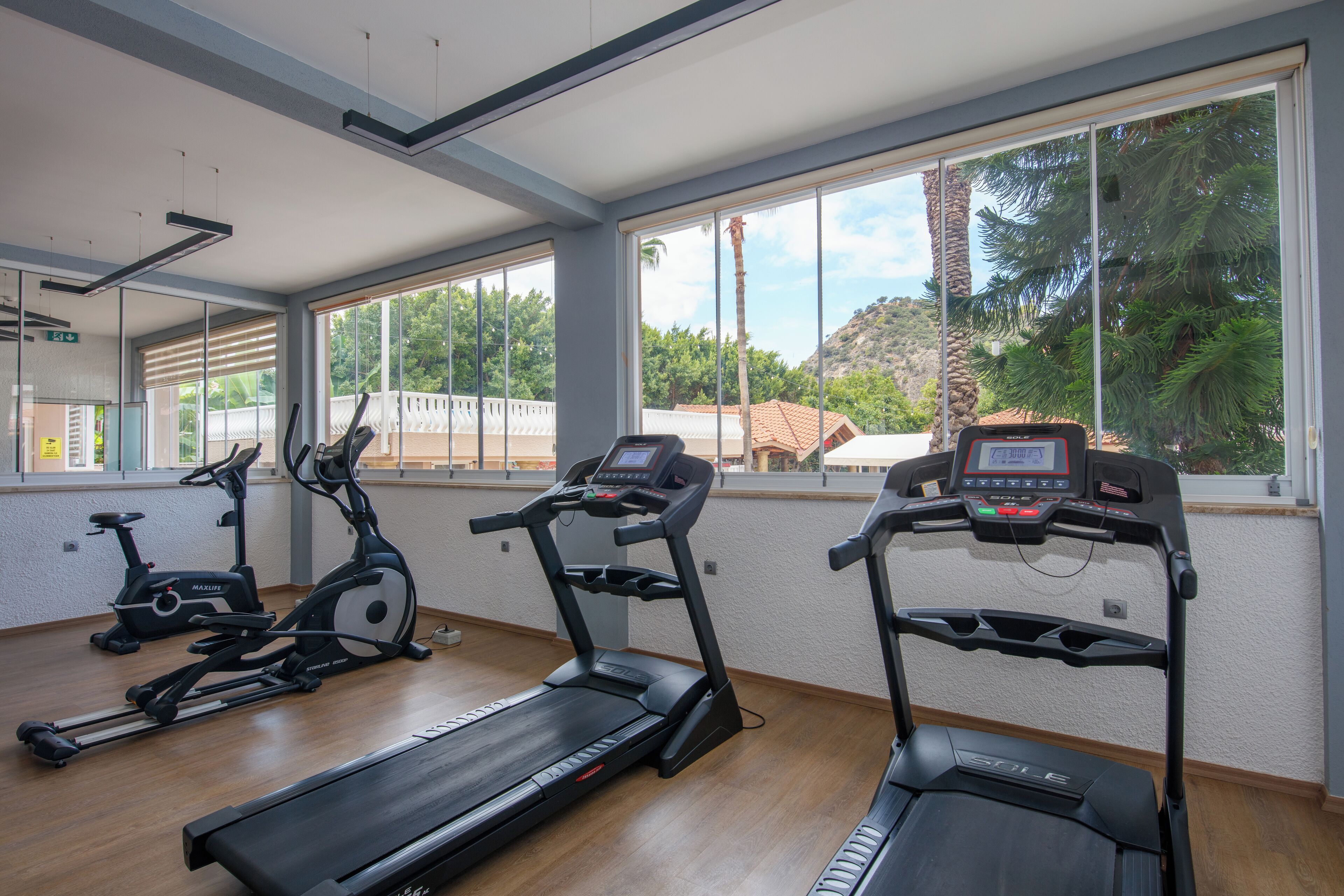 A gym with treadmills, stationary bikes, and a rowing machine.