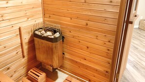Una sauna in legno con una rastrelliera metallica per le pietre.