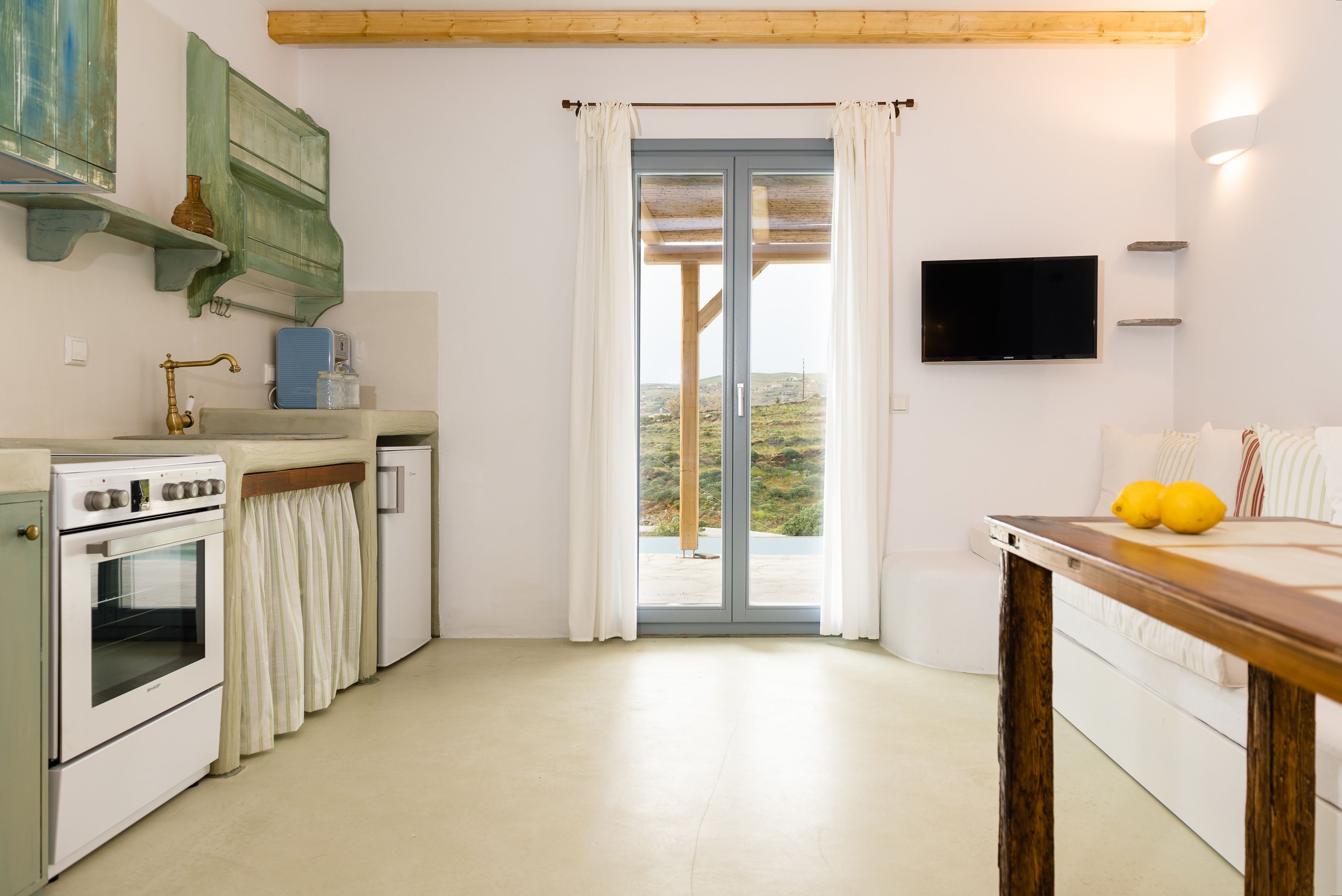 A kitchen with a built-in oven, a sink, and a wooden table with lemons.