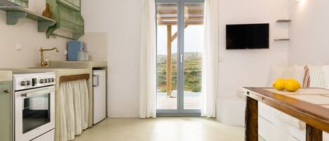 A kitchen with a built-in oven, a sink, and a wooden table with lemons.