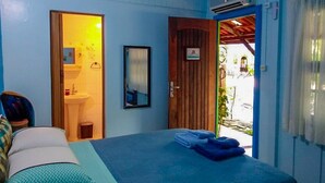 Un dormitorio con cama, baño y vistas al exterior.