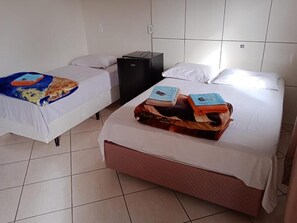 A hotel room with two beds, a small desk, and a tiled floor. - Pousadas Mafra (Mafra)