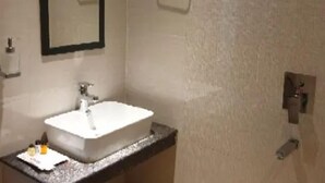 A bathroom with a white sink, a mirror, and a towel rack. - Hotel  Himalaya (Sidli)