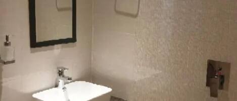 A bathroom with a white sink, a mirror, and a towel rack.