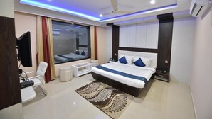 A modern hotel room with a large bed, a desk, a chair, and a large window with curtains. - Hotel  Himalaya (Sidli)