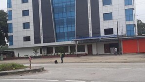 A modern multi-story building with a prominent glass facade and a flat roof. - Hotel  Himalaya (Sidli)