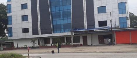Un moderno edificio de varios pisos con una fachada de vidrio destacada y techo plano.