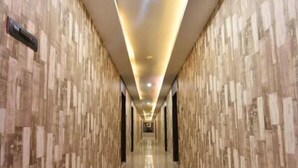 A long, narrow hallway with patterned walls and a polished floor, leading to a bright, illuminated end. - Hotel  Himalaya (Sidli)