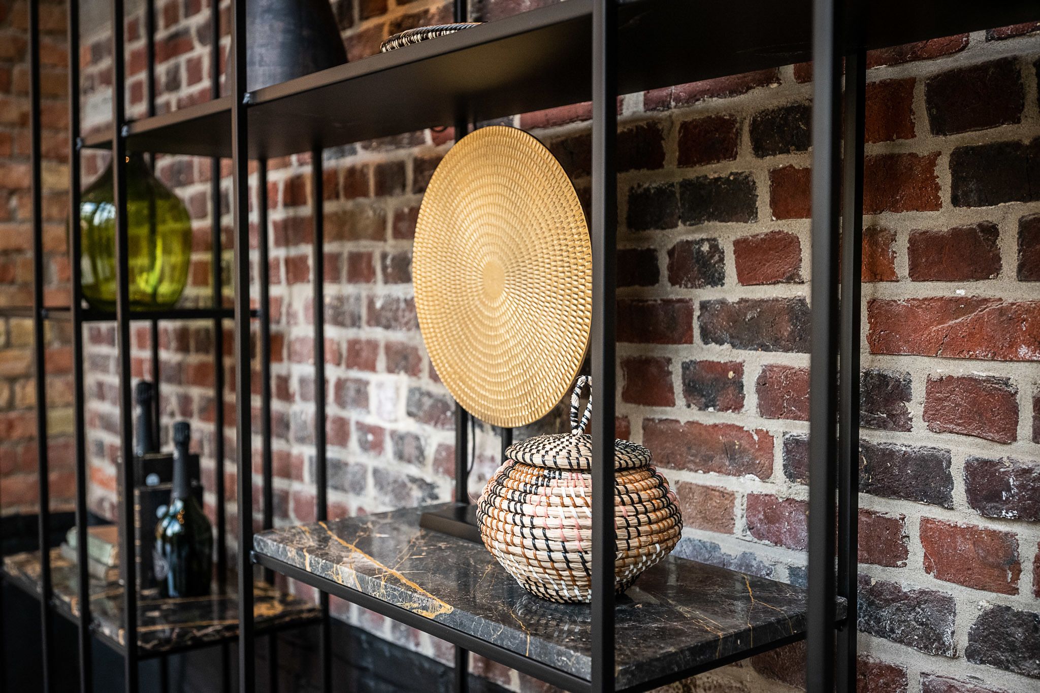 A brick wall with shelves holding decorative items.