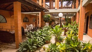A courtyard with brick walls, potted plants, and a staircase. - Elite Hotel (Florianópolis)