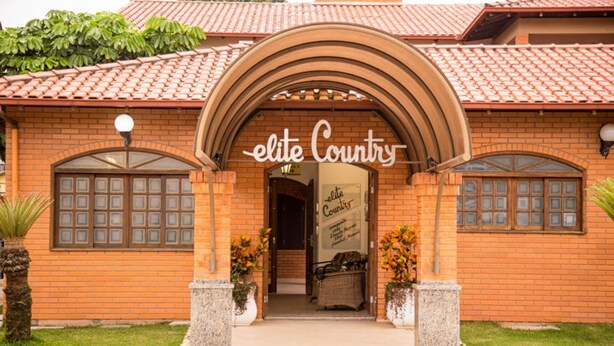 A building with a sign reading "elite Country" and a brick facade. - Elite Hotel (Florianópolis)