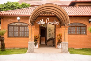 A building with a sign reading "elite Country" and a brick facade. - Elite Hotel (Florianópolis)