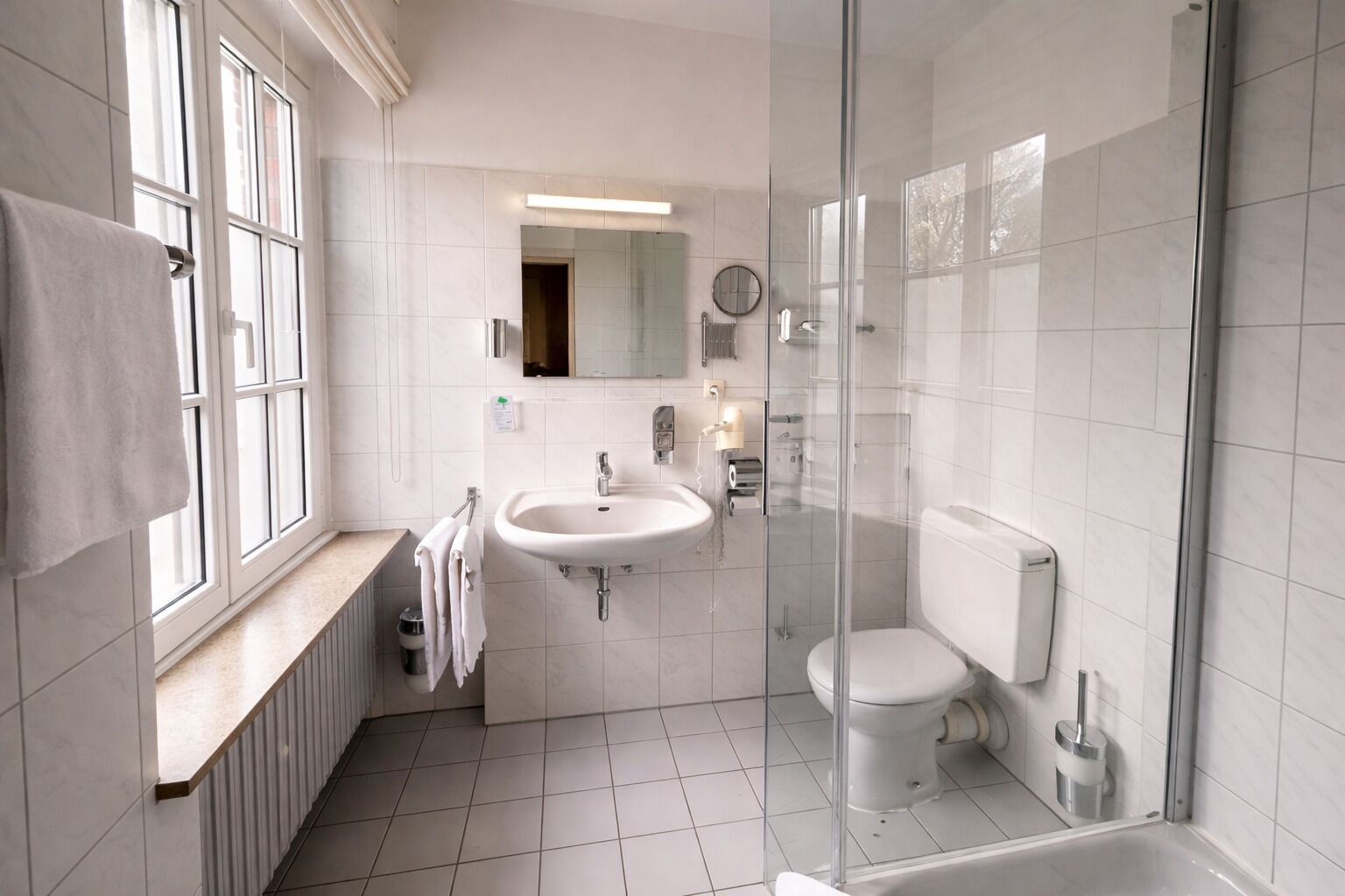 Un baño moderno con cabina de ducha de vidrio, lavabo e inodoro.