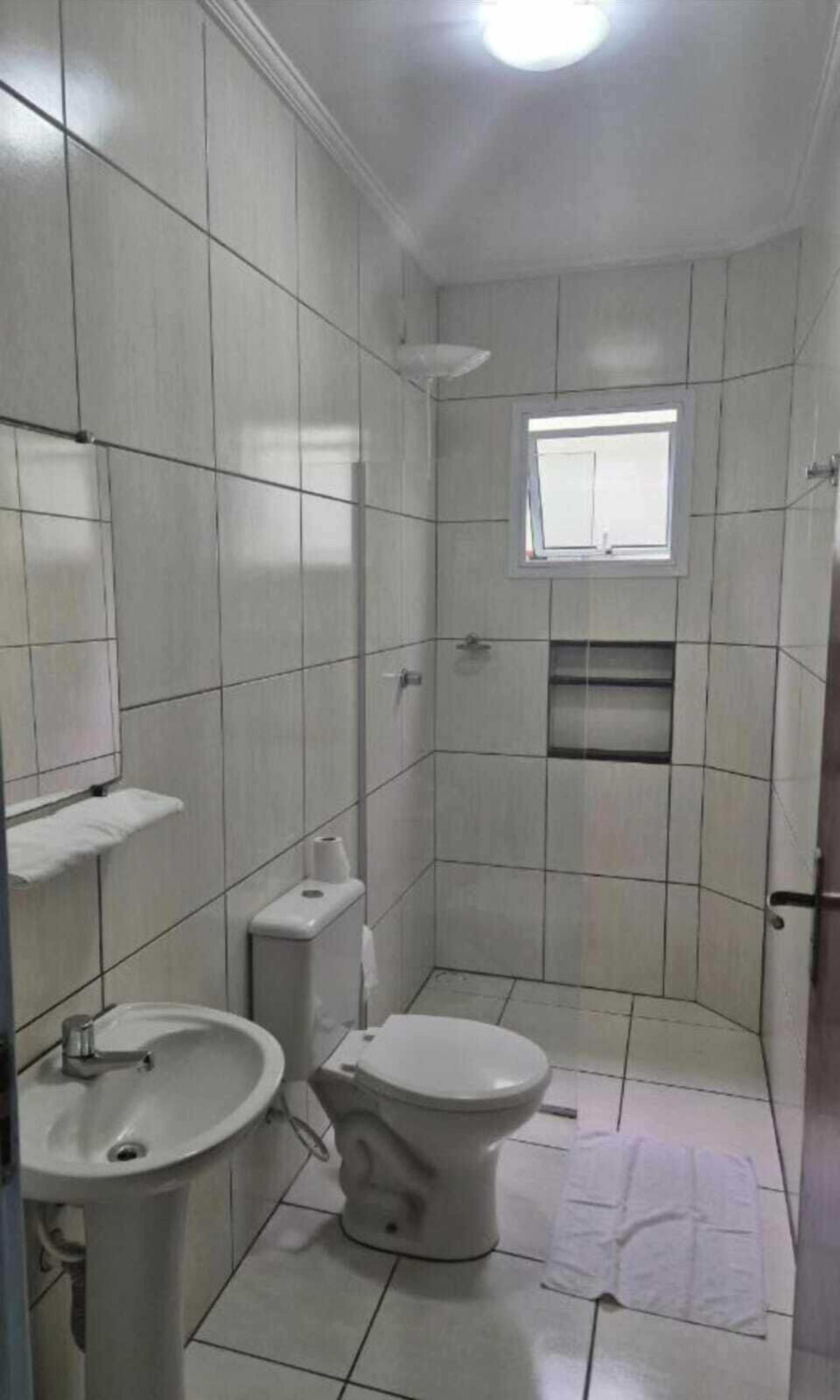 Chuveiro, toalhas de banho, papel higiênico 