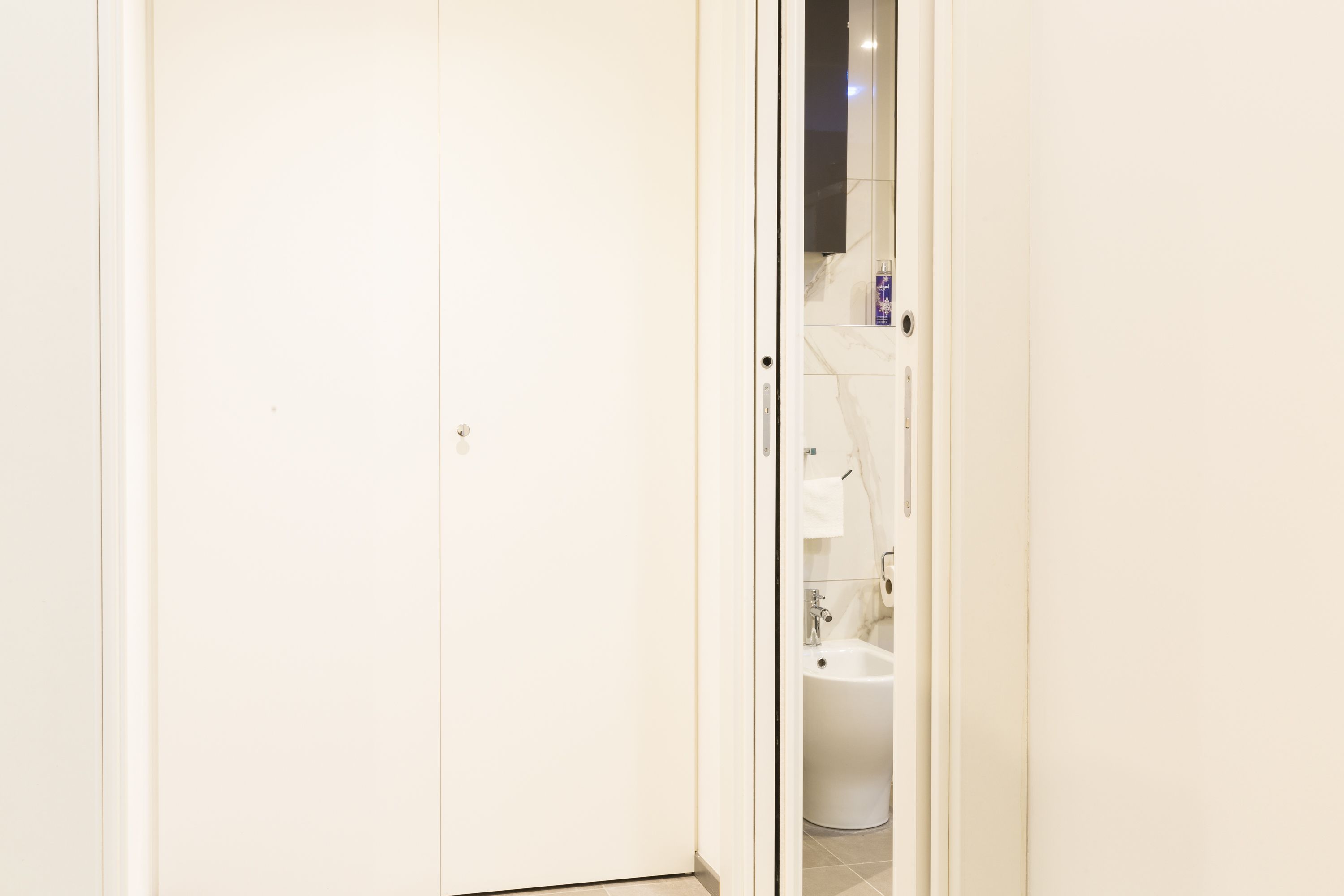 Ein helles Badezimmer mit Toilette, Bidet und Spiegel.