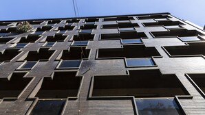 Un edificio moderno con una griglia di finestre rettangolari e balconi.