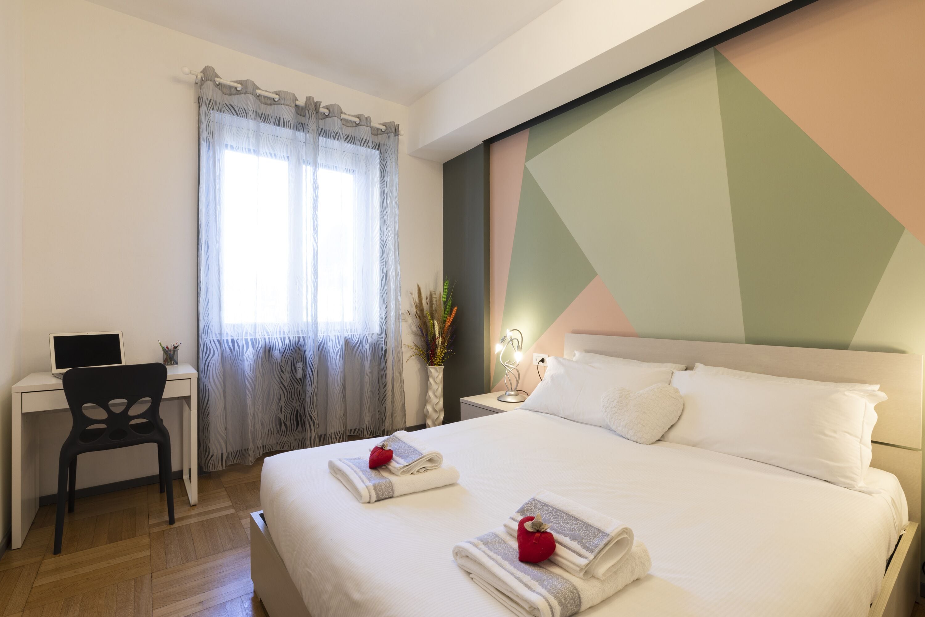 Een hotelkamer met een bed, een bureau en een stoel.