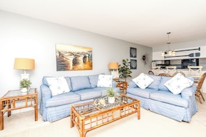 A living room with a sofa set, coffee table, and lamps. - Ocean Potion - Oceanfront Queen's Grant Condo with Amazing Views! (Topsail Beach)