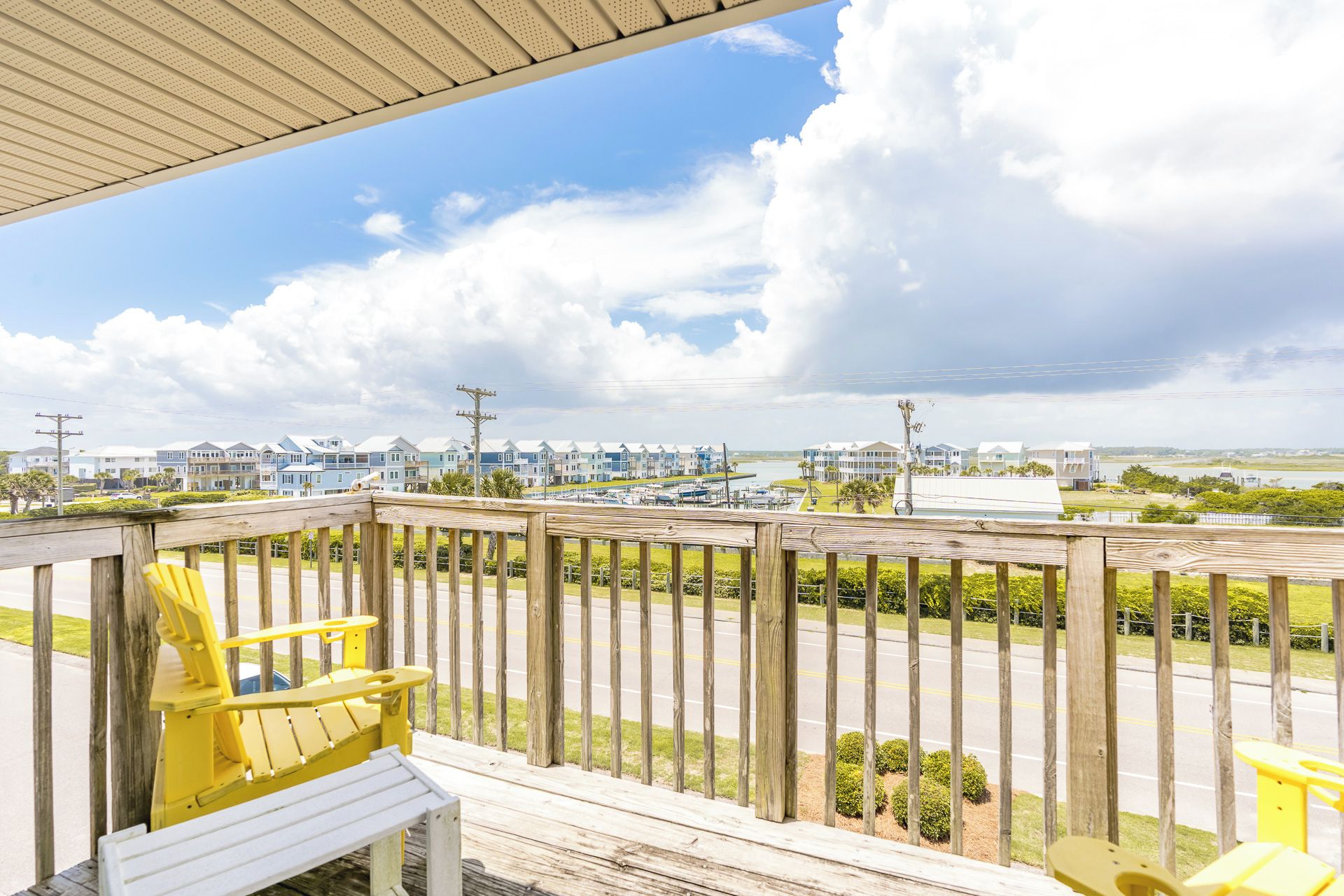 A wooden deck with a view of a marina and houses.