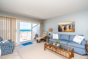 A living room with a sofa, chairs, a coffee table, and a painting.