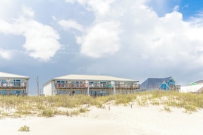 A beachfront property with multiple buildings, including a large blue structure with a balcony. - Ocean Potion - Oceanfront Queen's Grant Condo with Amazing Views! (Topsail Beach)
