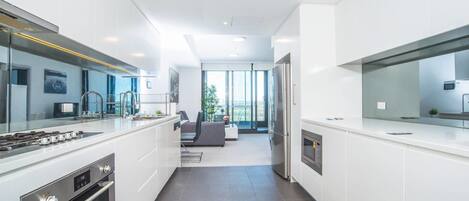 Appartement (1 Bedroom) | Privékeuken | Een koelkast, een microgolfoven, kookgerei, borden en bestek