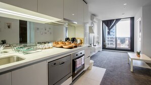 A modern kitchen with a large island, built-in appliances, and a view to the outside. - New Renovated & Cozy Apt Closes To Southern Cross (Melbourne)