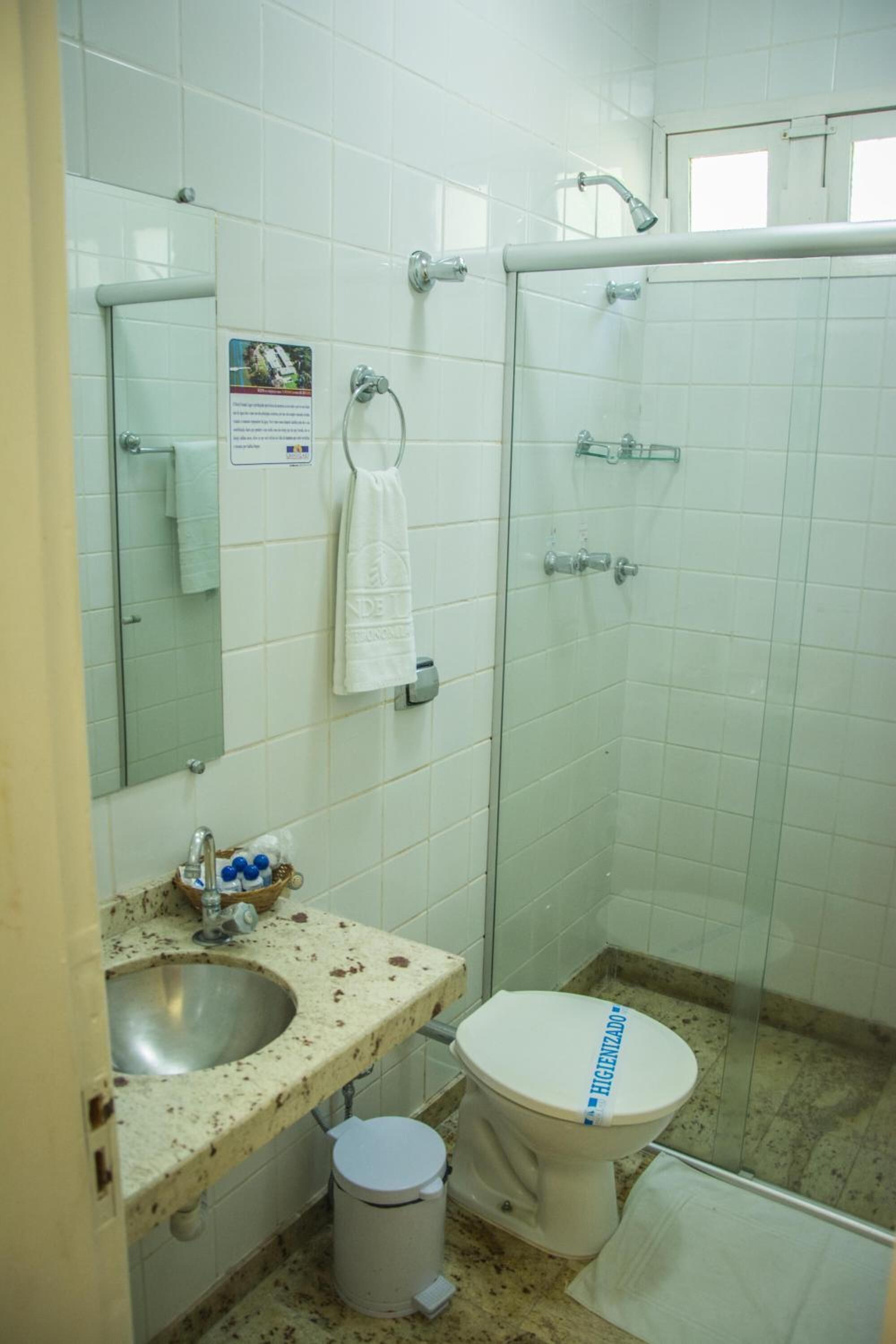 Une salle de bain avec un lavabo, des toilettes et une douche.
