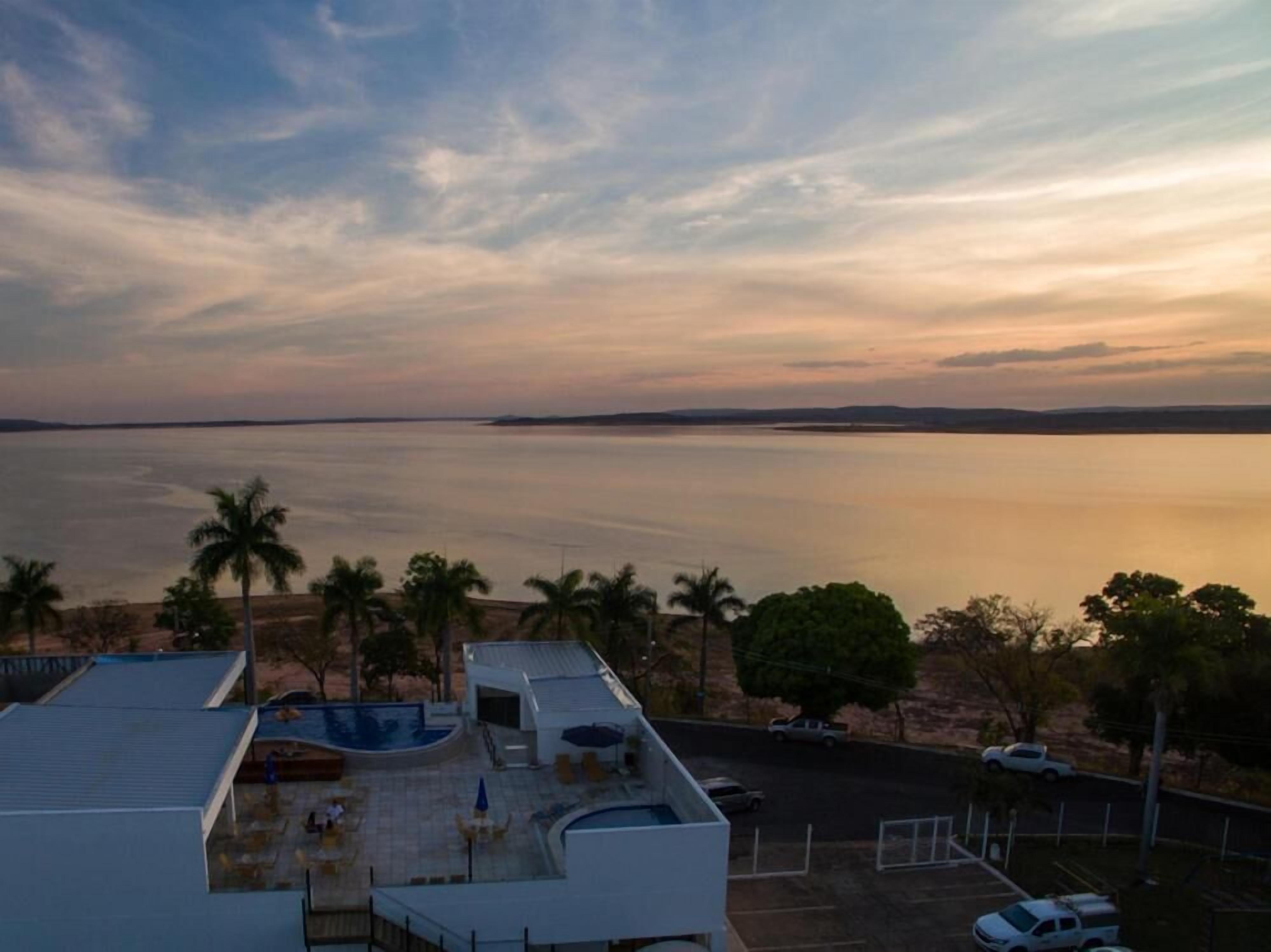 A resort with a pool, outdoor seating, and a view of the ocean.