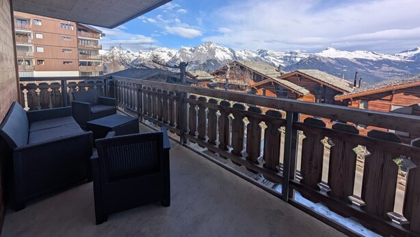 A balcony with wicker furniture overlooking a mountain landscape and traditional buildings. - Pracondu 1 101 - OUTDOOR & FUN  apartment 8 pers (Haute-Nendaz)