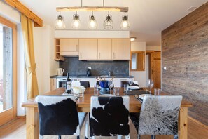 Une cuisine moderne avec des meubles en bois, un îlot central et un coin repas avec des chaises.