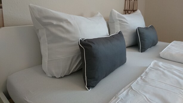 A light grey sofa with white and dark grey cushions. - City Apartment S & W (Hamburg)