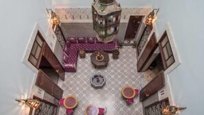 A rooftop terrace with a seating area, a decorative lantern, and a patterned floor. - Riad Baba (Fes)