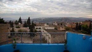 A cityscape with buildings and a cloudy sky. - Riad Baba (Fes)