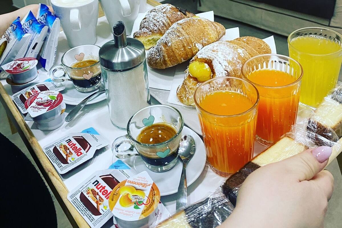 A breakfast table with pastries, coffee, and juice.