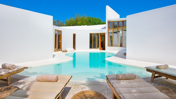 A modern pool area with lounge chairs and a clear blue pool. - Villa Ixia (Rhodes)