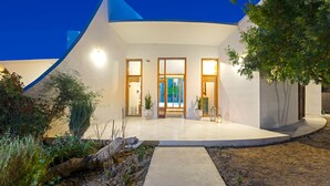 A modern building with a curved facade, large windows, and a well-lit entrance. - Villa Ixia (Rhodes)
