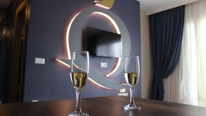 A room with a dark wall, a crown-shaped decoration, and two glasses of wine on a wooden table. - Quars Suite (Istanbul)